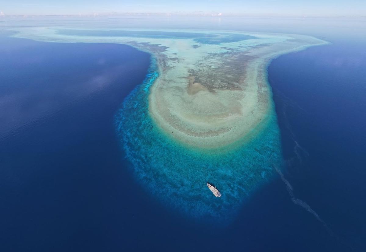 Aerial view of the Resolute liveaboard cruising with a panoramic backdrop of the Philippine seascape